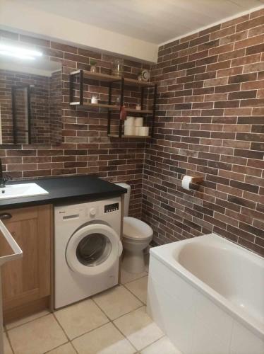 La salle de bains est pourvue de toilettes, d'un lavabo et d'une baignoire. dans l'établissement Appartement à la Montagne, à Saint-Gervais-les-Bains