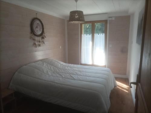 ein Schlafzimmer mit einem Bett und einer Uhr an der Wand in der Unterkunft Appartement à la Montagne in Saint-Gervais-les-Bains