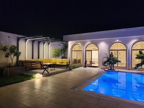 a house with a swimming pool at night at منتجع آركو ARCO Resort in Al Wudayy