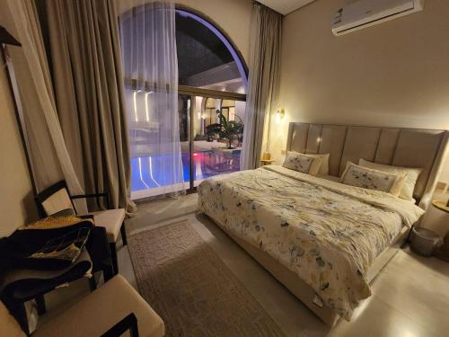 a bedroom with a bed and a large window at منتجع آركو ARCO Resort in Al Wudayy