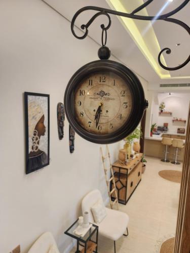 a clock hanging on a wall in a living room at منتجع آركو ARCO Resort in Al Wudayy