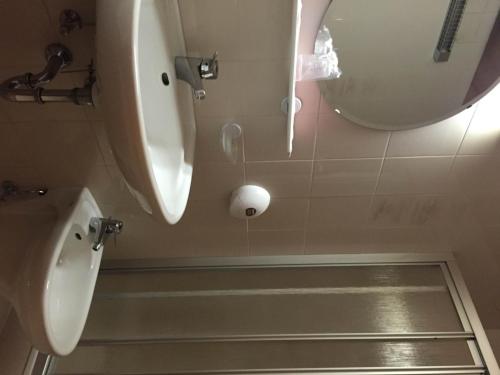 a bathroom with two urinals and a sink and a toilet at Hotel Bachmann in Villabassa