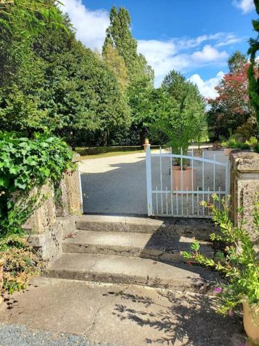 une porte menant à une allée avec des escaliers et des arbres dans l'établissement La Grelauderie 7, à Saintes