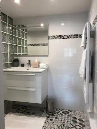 une salle de bain blanche avec un lavabo et une douche dans l'établissement Deauville les pieds dans l'eau, à Deauville