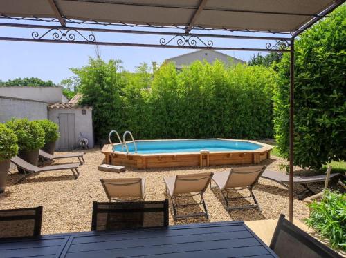 une cour avec une piscine, des chaises et un parasol dans l'établissement Un Coin de Provence, à LʼIsle-sur-la-Sorgue