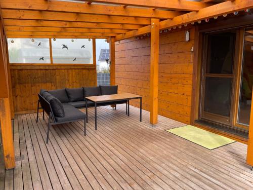 a patio with a couch and a table on a deck at Gästehaus Carpe Diem in Kappel-Grafenhausen
