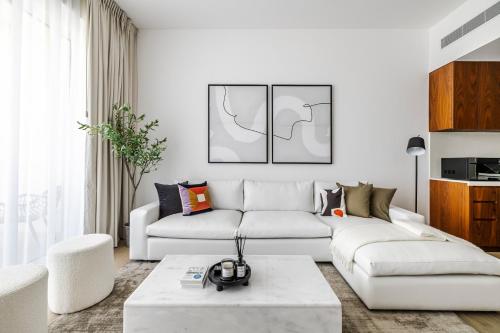 Una sala de estar con un sofá blanco y una mesa. en 1BR Le Pont B1 Sea View, en Dubái