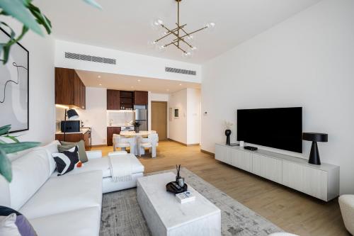 a living room with white furniture and a flat screen tv at 1BR in Le Pont Private Beach Access in Dubai