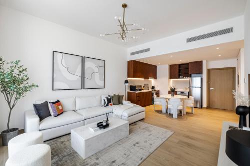 a living room with a white couch and a table at 1BR in Le Pont Private Beach Access in Dubai