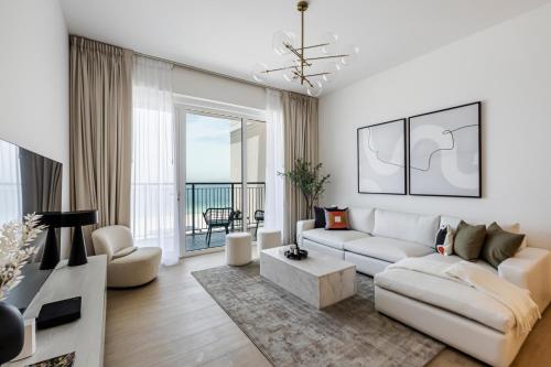a living room with a white couch and a table at 1BR in Le Pont Private Beach Access in Dubai