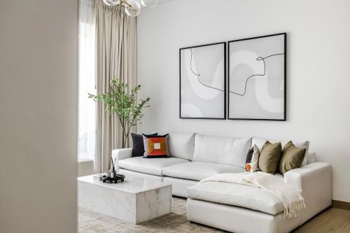 Una sala de estar con un sofá blanco y una mesa. en 1BR Le Pont B1 Sea View, en Dubái