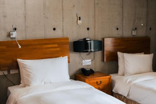 a room with two beds and a tv on the wall at The Light in Hengchun