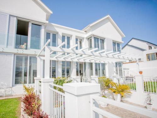 a white house with a white pergola at Beautiful Gate in George