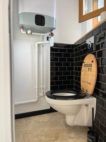 une salle de bain avec toilettes avec un siège de toilette en bois dans l'établissement Gîte le Davidson, maison avec jardin, à Ypreville-Biville