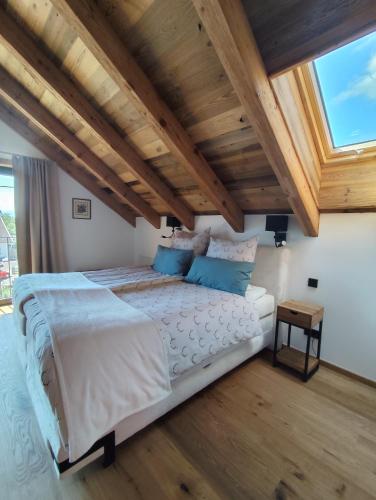 a bedroom with a large bed with a wooden ceiling at Lechrain Chalet - 5 Sterne Ferienhaus - für 6 Personen - Biohof zwischen Ammersee und Lech in Reichling