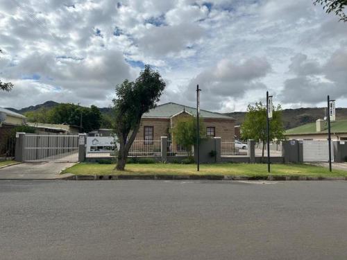 an empty street in front of a house with a fence at Conti-INN Guesthouse in Queenstown