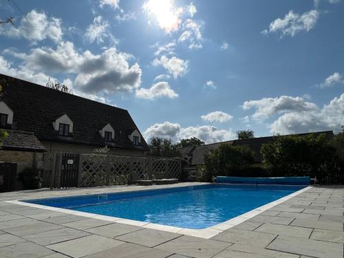 a swimming pool in the backyard of a house at Stable Cottage, Oxfordshire in Oxford
