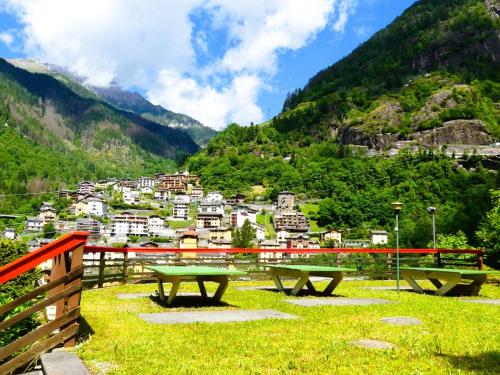 a group of picnic tables in front of a mountain at ALLA CASCATA in centro Branzi self check-in parcheggio gratuito coperto in Branzi