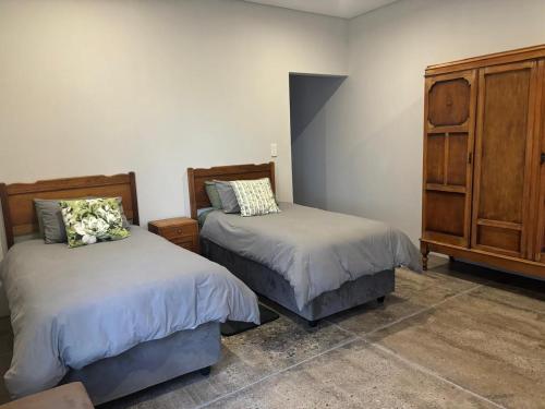 Un dormitorio con dos camas y una cómoda. en Elements Golfers Lodge 123, en Moheme