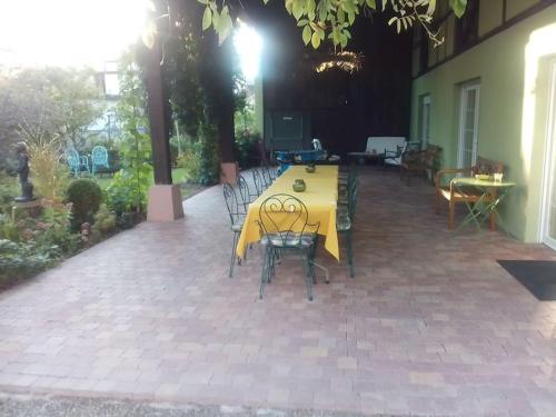 a yellow table and chairs on a patio at night at La grange de Manu in Richtolsheim