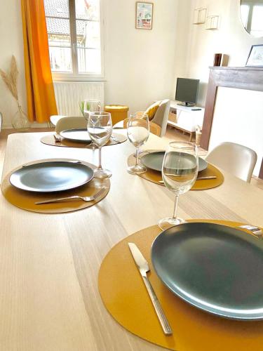 une table en bois avec des assiettes et des verres à vin dessus dans l'établissement Le Duplex, magnifique centre historique, à Limoges