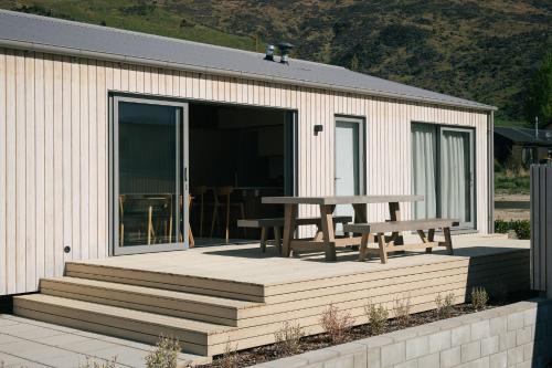 a patio with a table and a picnic table at Abodo Alpine Eco Villa in Cardrona