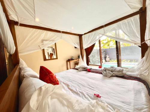 a bedroom with a white bed with a canopy at AS Resort in Ubud