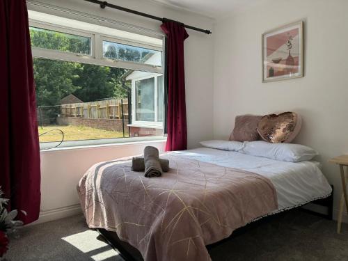 a bedroom with a bed in front of a window at 3 bedroom cosy home in Birmingham in Oldbury