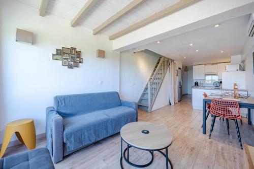 un salon avec un canapé bleu et une table dans l'établissement 3 pièces proche parc naturel et mer, parking, climatisation, à Villeneuve-Loubet