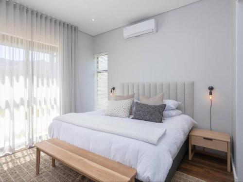 a white bedroom with a large bed and a window at Luxury Villa 712 Pearl Valley Golf Estate in Paarl