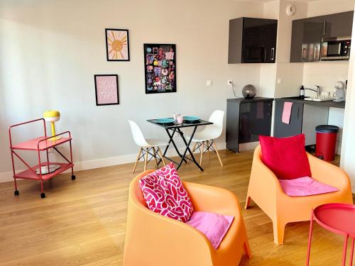 un salon avec des chaises orange et une table dans l'établissement Au cœur de Toulouse Appartement coloré, à Toulouse