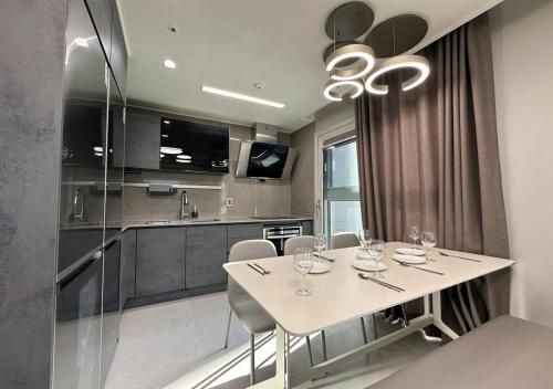 a kitchen with a white table and chairs in a room at Y COLLECTION by UH FLAT OSIRIA in Busan
