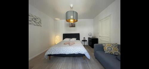 une chambre avec un lit et un canapé bleu dans l'établissement Appartement neuf chic urbain, à Dijon