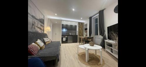 un salon avec un canapé et une table dans l'établissement Appartement neuf chic urbain, à Dijon