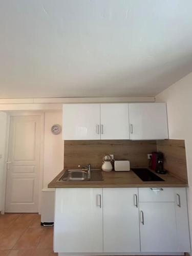 une cuisine avec des armoires blanches et un évier dans l'établissement Très joli appartement Saint-Raphaël, à Saint-Raphaël