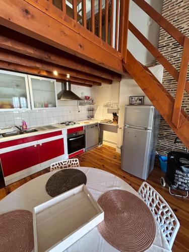 a kitchen with a table and a refrigerator and a counter at Appartement au cœur de Périgueux in Périgueux