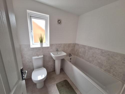 a bathroom with a toilet and a sink and a bath tub at Cefneithin House - Carmarthenshire in Cross Hands