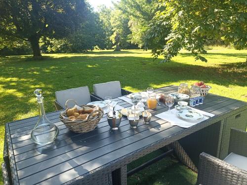 a picnic table with a basket of food on it at Le Bonheur du Périgord - Chambre d'hôte in Mialet