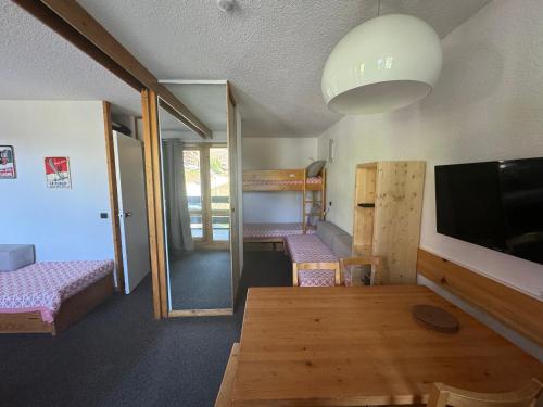 une chambre avec deux lits superposés et une télévision dans l'établissement Studio divisible fonctionnel au pied des pistes avec balcon - FR-1-181-2280, à La Plagne Tarentaise