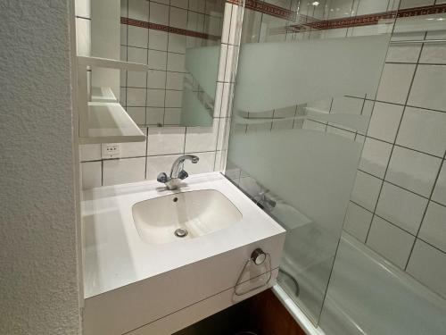 une salle de bain blanche avec un lavabo et une douche dans l'établissement Studio divisible fonctionnel au pied des pistes avec balcon - FR-1-181-2280, à La Plagne Tarentaise
