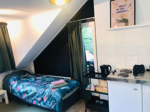 a small bedroom with a bed and a window at Studio Enschede Twente - Rust, natuur & gratis parkeren in Enschede