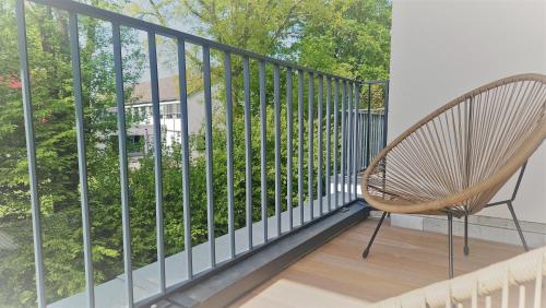 a chair sitting on a balcony with a view of trees at Townlofts am Borussia Park in Mönchengladbach