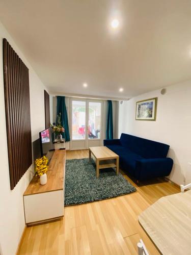 un salon avec un canapé bleu et une table dans l'établissement Flat near paris, à Épinay-sur-Seine