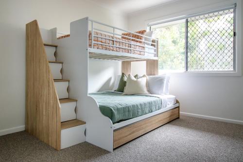 a bedroom with a bunk bed and a window at Palms on Tugun in Gold Coast