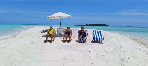 three people sitting in lawn chairs on a beach at Rindali - The speedboat from Malé to the hotel departs at 1130 every Monday Thursday and Saturday and from the hotel to Malé at 0630 and five domestic flights are available every day in Dhaalu Atoll