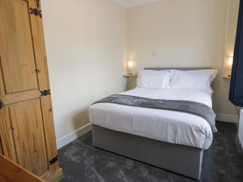 a bedroom with a bed with white sheets and pillows at West Morton Suite in Thornhill