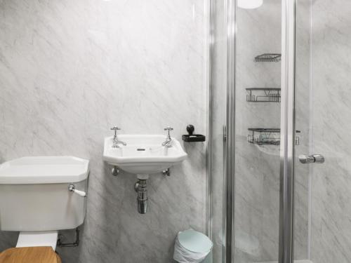 a white bathroom with a sink and a shower at West Morton Suite in Thornhill