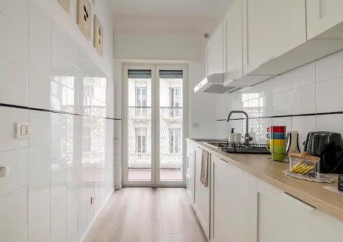 So Fine Petruzzelli flat في باري: مطبخ مع دواليب بيضاء ونافذة كبيرة
