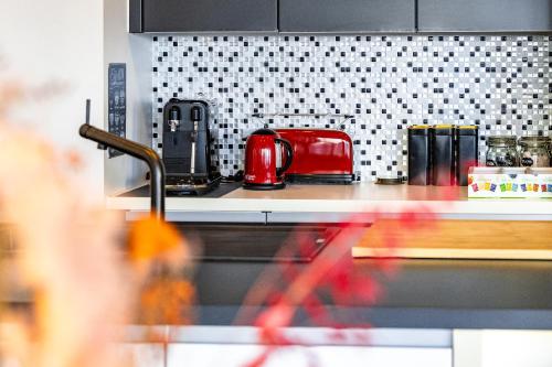 a kitchen counter with a red toaster on a stove at London 993 Apt 202 in Antwerp