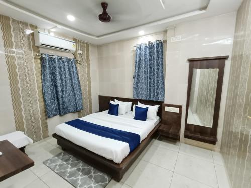 德瓦尔卡Hotel Shree Nath - 200 Meters from Dwarkadhish Temple的卧室里有一张大床，配有蓝色枕头